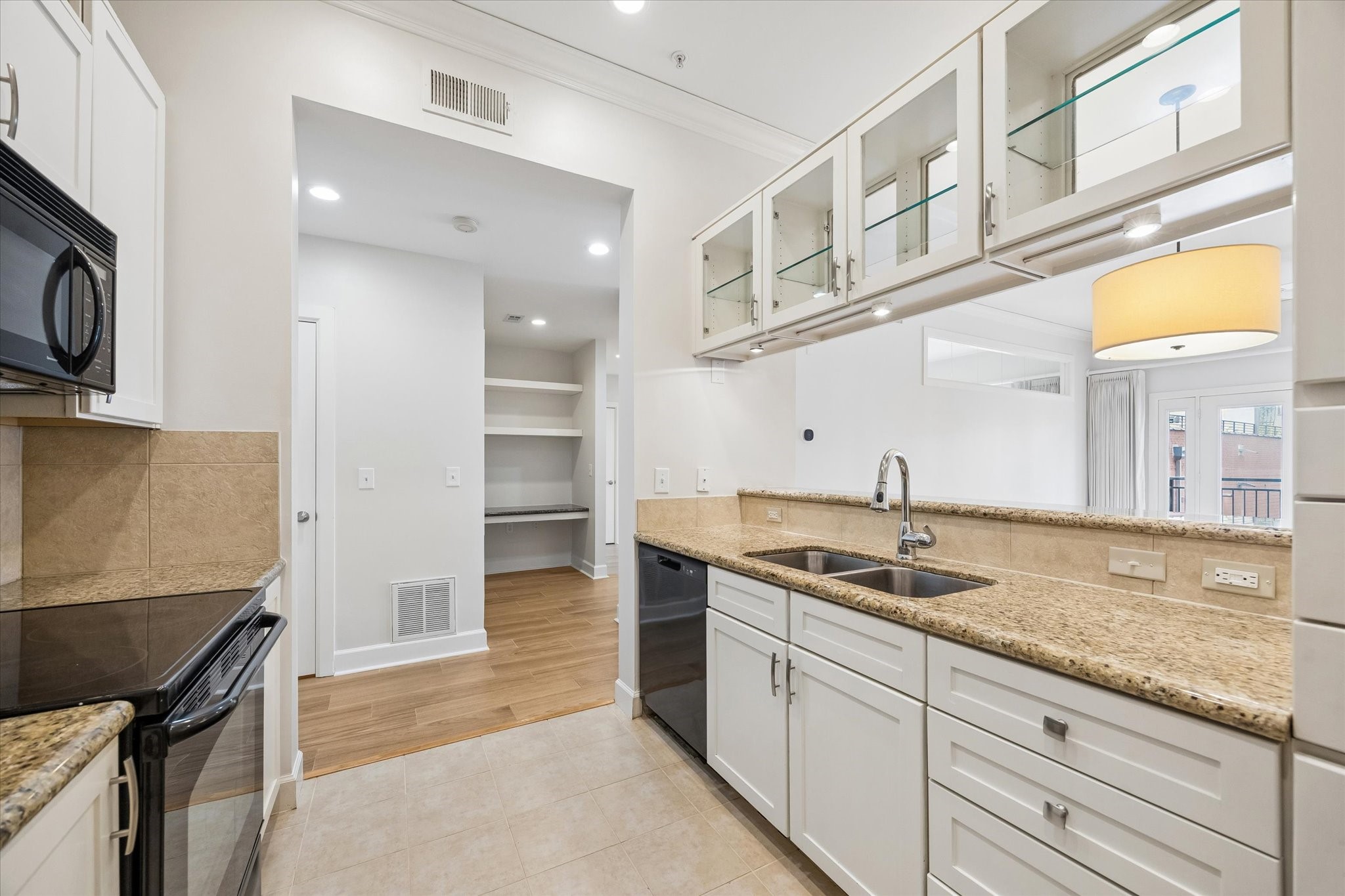 100 Willard Street, Unit 15 Houston, TX 77006 - Photo 9 of 25 A functional and stylish kitchen layout with breakfast bar seating, under-cabinet lighting, and open views into the living space for easy entertaining.