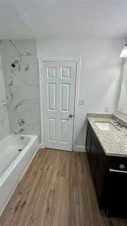 a bathroom with a granite countertop sink toilet and bathtub