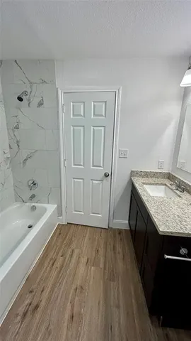 a bathroom with a granite countertop sink toilet and bathtub