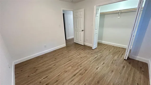 an empty room with wooden floor and door