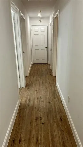 a view of a hallway with wooden floor
