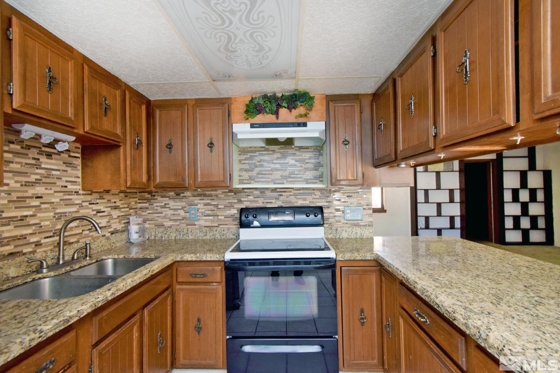 1279 Ebbetts Drive Reno, NV 89503 - Photo 14 of 37 a kitchen with stainless steel appliances granite countertop a stove a sink and a microwave