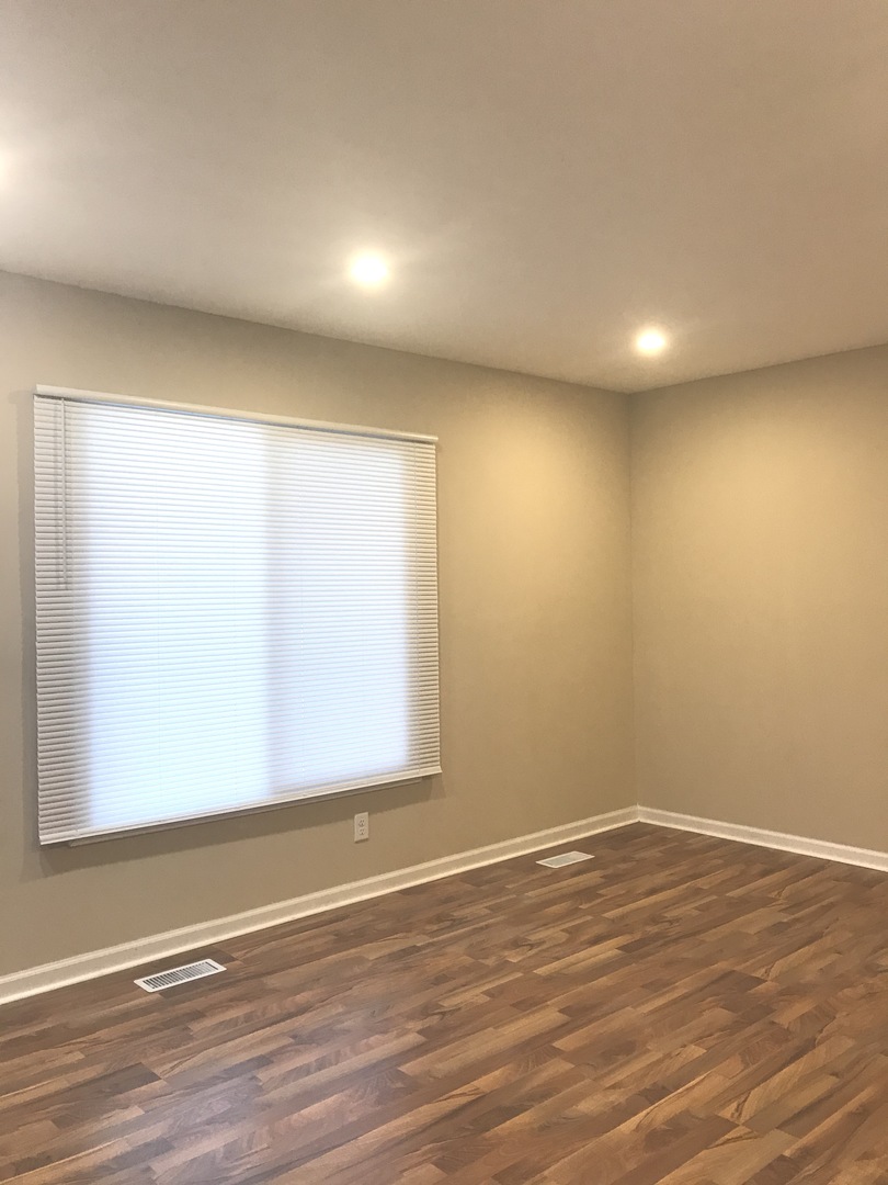 309 Rockhurst Road Bolingbrook, IL 60440 - Photo 2 of 17 an empty room with wooden floor and windows