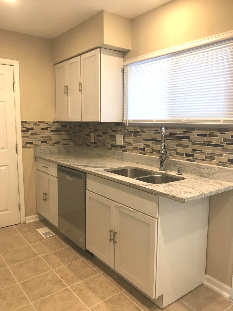 309 Rockhurst Road Bolingbrook, IL 60440 - Photo 6 of 17 a kitchen with a sink cabinets and wooden floor