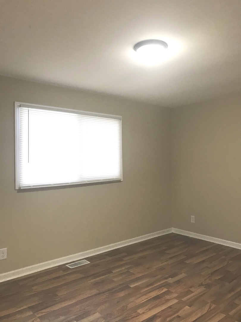 309 Rockhurst Road Bolingbrook, IL 60440 - Photo 8 of 17 an empty room with wooden floor and windows
