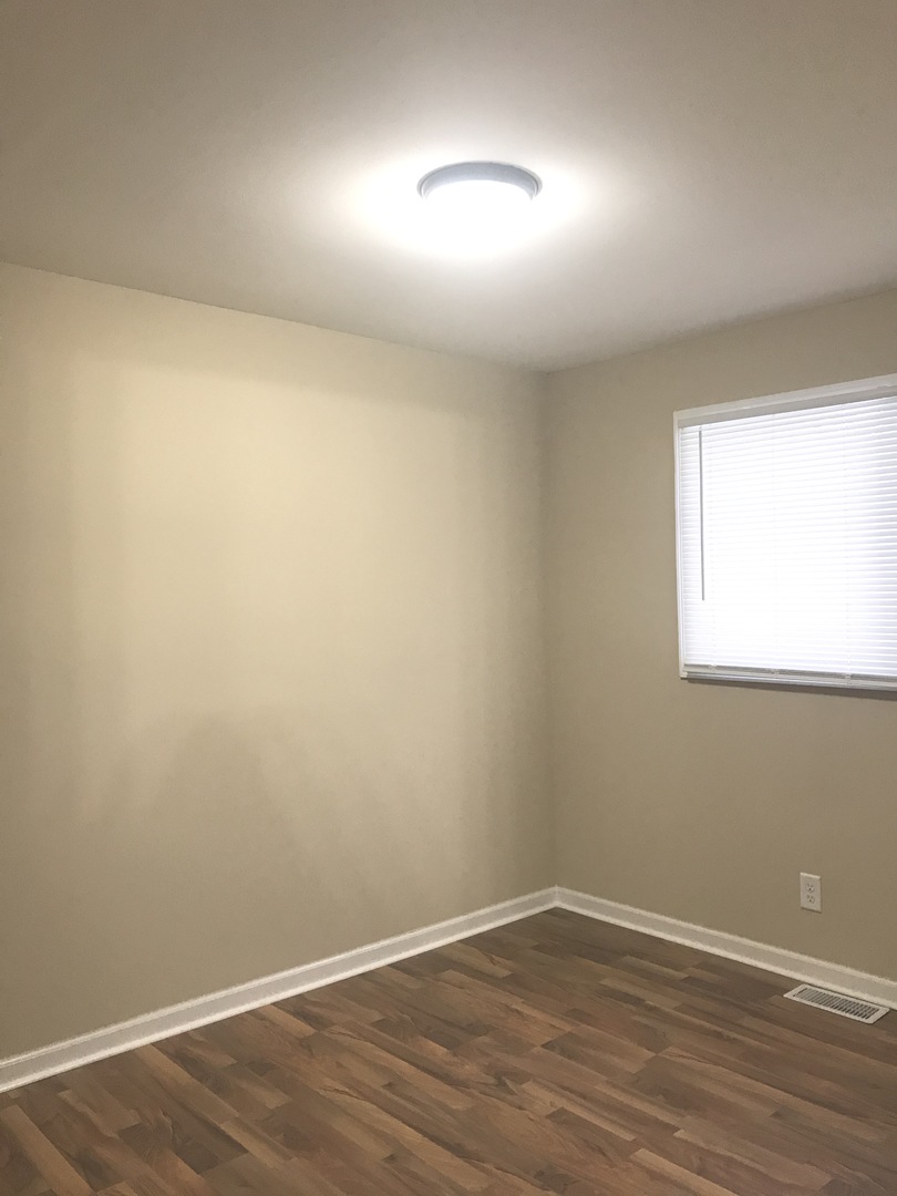 309 Rockhurst Road Bolingbrook, IL 60440 - Photo 9 of 17 an empty room with wooden floor and windows