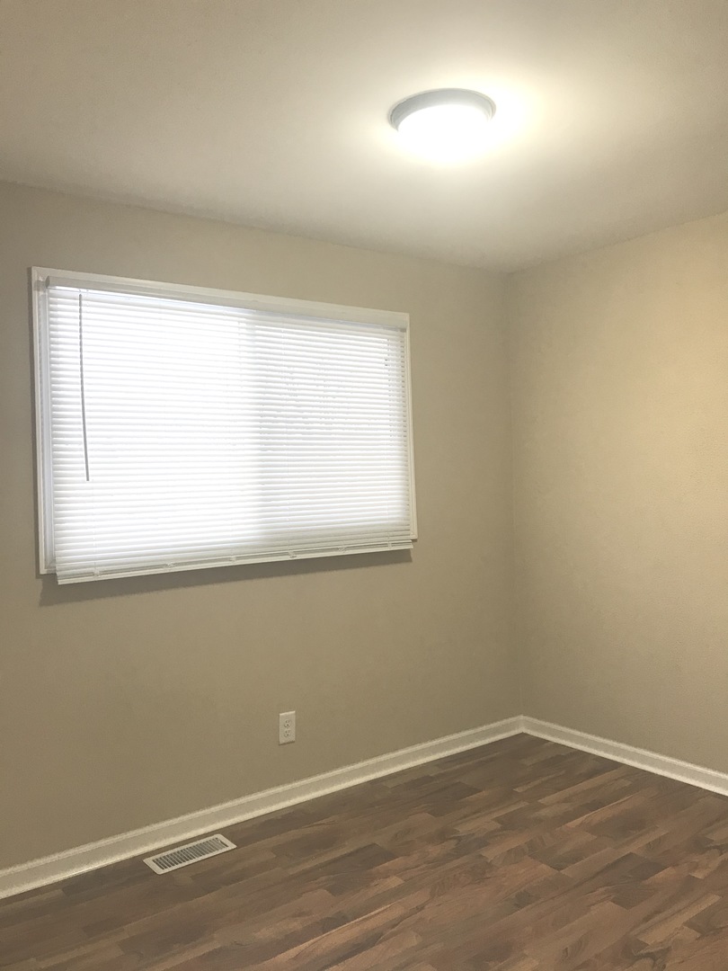 309 Rockhurst Road Bolingbrook, IL 60440 - Photo 10 of 17 an empty room with wooden floor and windows