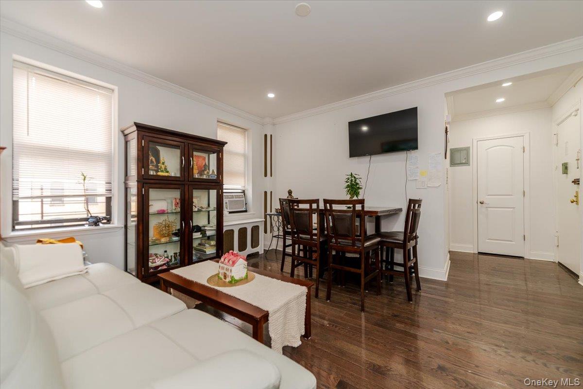 37-21 80th Street, Unit 4H Queens, NY 11372 - Photo 3 of 12 a living room with furniture a window and a flat screen tv