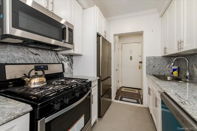 a kitchen with stainless steel appliances granite countertop a stove and a microwave