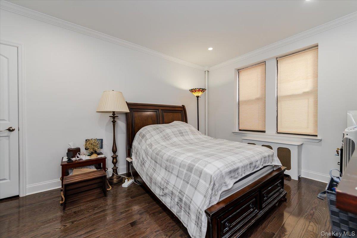 37-21 80th Street, Unit 4H Queens, NY 11372 - Photo 8 of 12 a bedroom with a bed and wooden floor