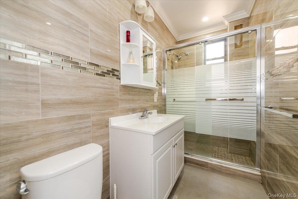 37-21 80th Street, Unit 4H Queens, NY 11372 - Photo 10 of 12 a bathroom with a sink toilet and shower