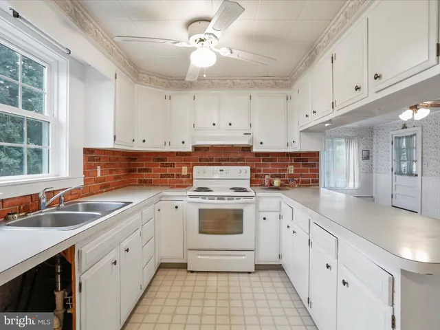 a kitchen with stainless steel appliances granite countertop a sink and dishwasher with white cabinets