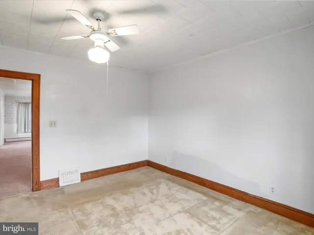 an empty room with a chandelier fan