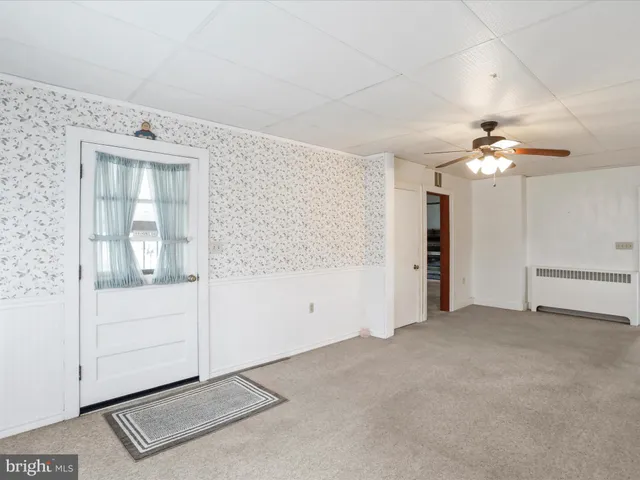 a view of an empty room with cabinet and a window