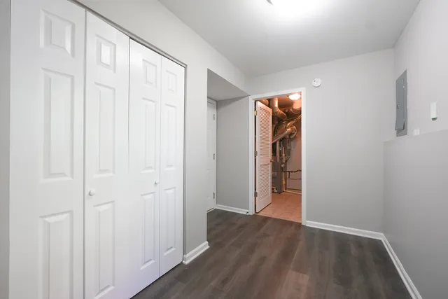 a view of an empty room with wooden floor and entryway