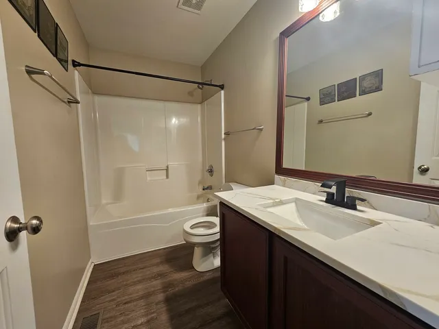 a bathroom with a sink a toilet a mirror and shower