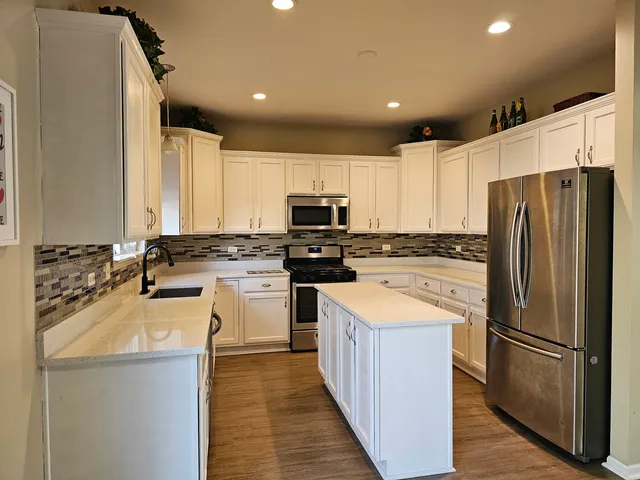 a kitchen with a refrigerator a sink and a microwave