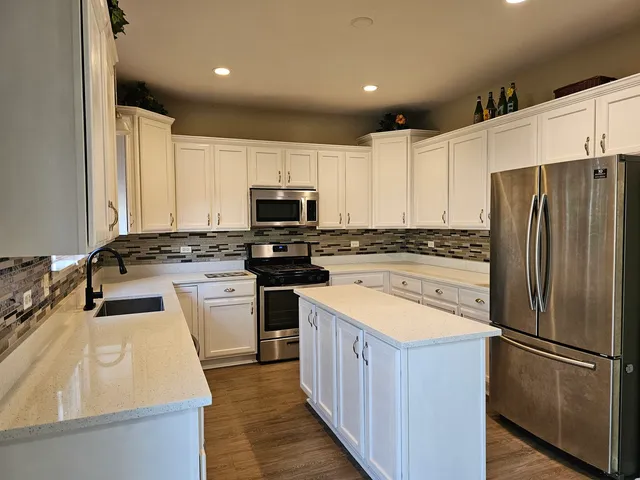 a kitchen with a refrigerator a sink and a stove top oven