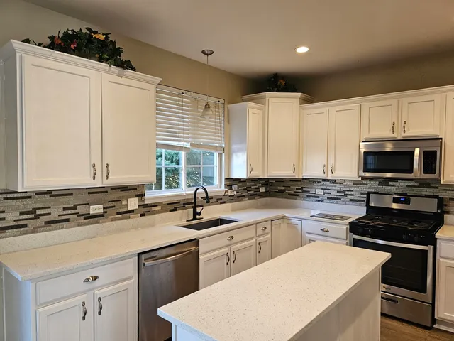 a kitchen with a sink stove and cabinets