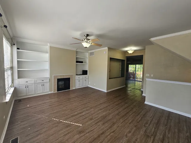 a view of empty room with wooden floor and fireplace