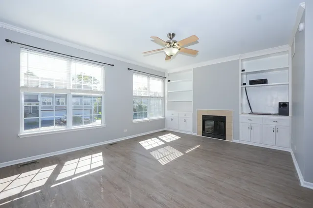 a view of empty room with a fireplace and wooden floor