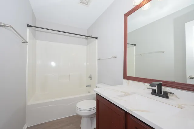 a bathroom with a granite countertop sink toilet and shower