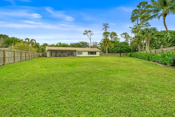 a view of a big yard with a house in the background