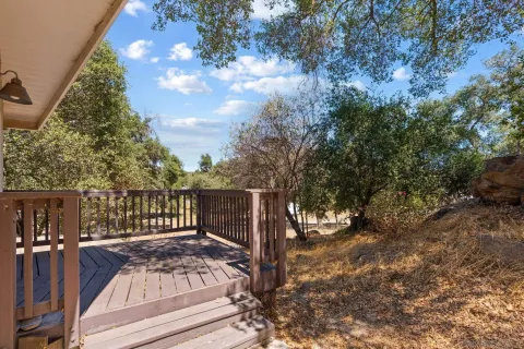 a view of balcony with wooden floor and fence
