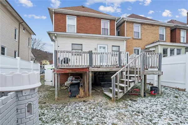 a view of a house with wooden deck and furniture