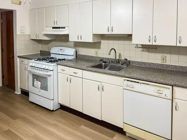 a kitchen with white cabinets and white appliances