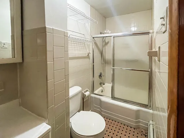 a bathroom with a toilet and a shower