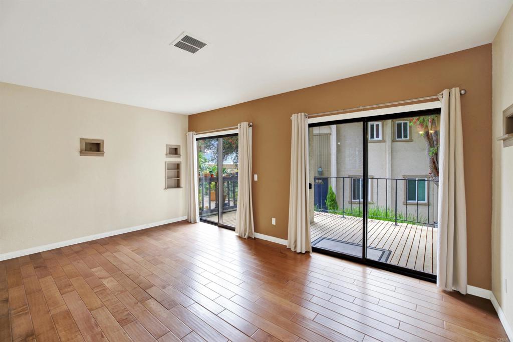 2383 Altisma Way, Unit D Carlsbad, CA 92009 - Photo 11 of 40 a view of an empty room with wooden floor and a window