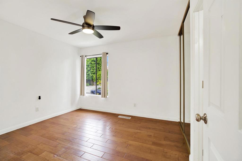 2383 Altisma Way, Unit D Carlsbad, CA 92009 - Photo 18 of 40 a view of empty room with wooden floor and fan