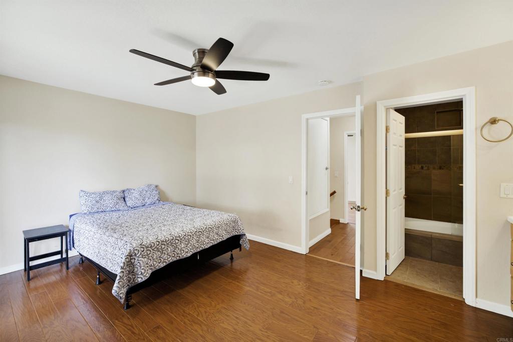 2383 Altisma Way, Unit D Carlsbad, CA 92009 - Photo 22 of 40 a bedroom with a bed and a walk in closet with wooden floor