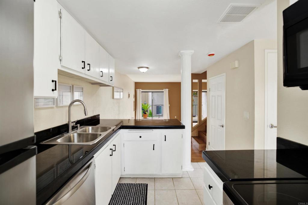 2383 Altisma Way, Unit D Carlsbad, CA 92009 - Photo 5 of 40 a kitchen with granite countertop a sink stainless steel appliances and cabinets