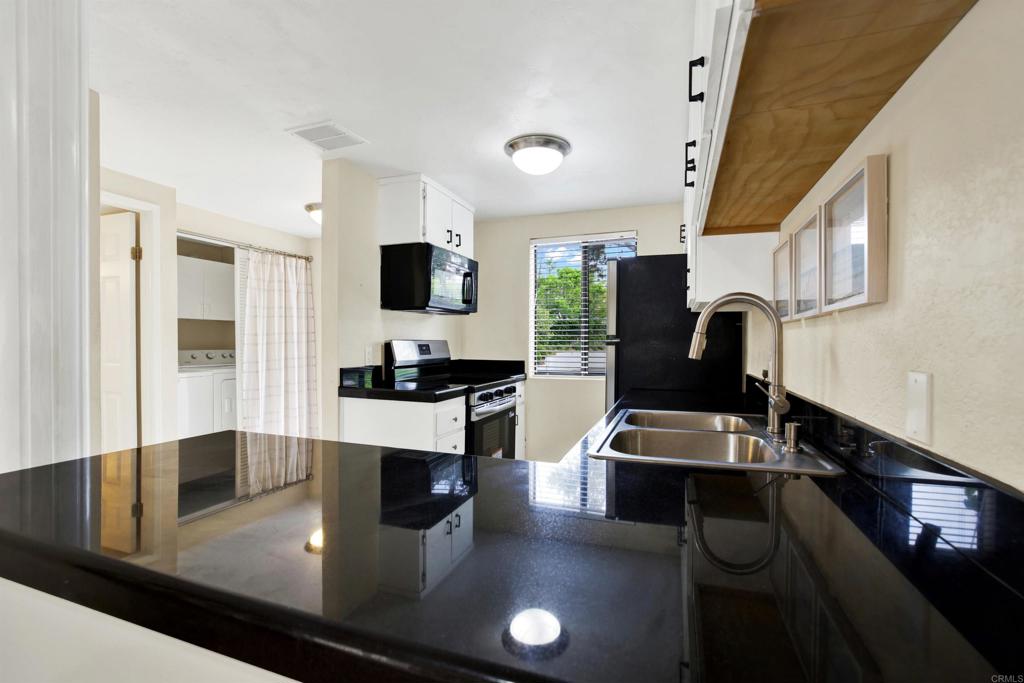 2383 Altisma Way, Unit D Carlsbad, CA 92009 - Photo 6 of 40 a kitchen with stainless steel appliances granite countertop a sink stove and refrigerator