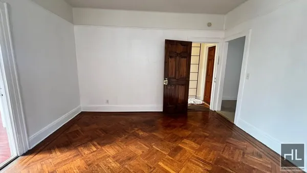 a view of an empty room with closet and a window