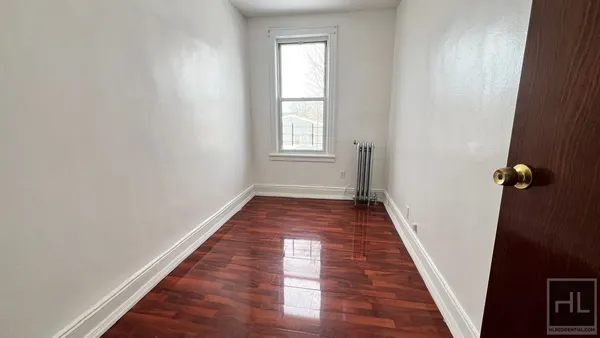 a view of a hallway with wooden floor and closet