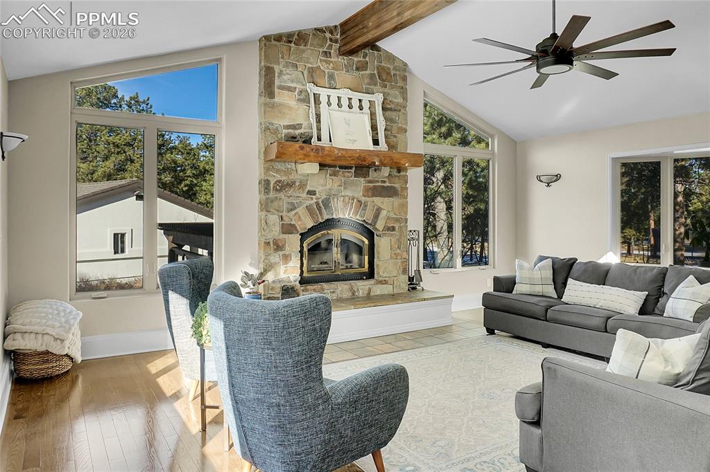 17350 Goshawk Road Colorado Springs, CO 80908 - Photo 7 of 50 a living room with furniture a fireplace and a floor to ceiling window