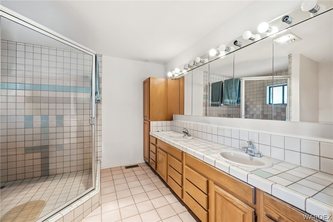 2401 North Stephan Road Kingman, AZ 86401 - Photo 53 of 92 a bathroom with a granite countertop sink a large mirror and shower