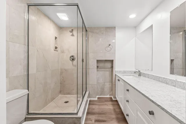 a bathroom with a granite countertop sink a mirror a shower and a bathtub