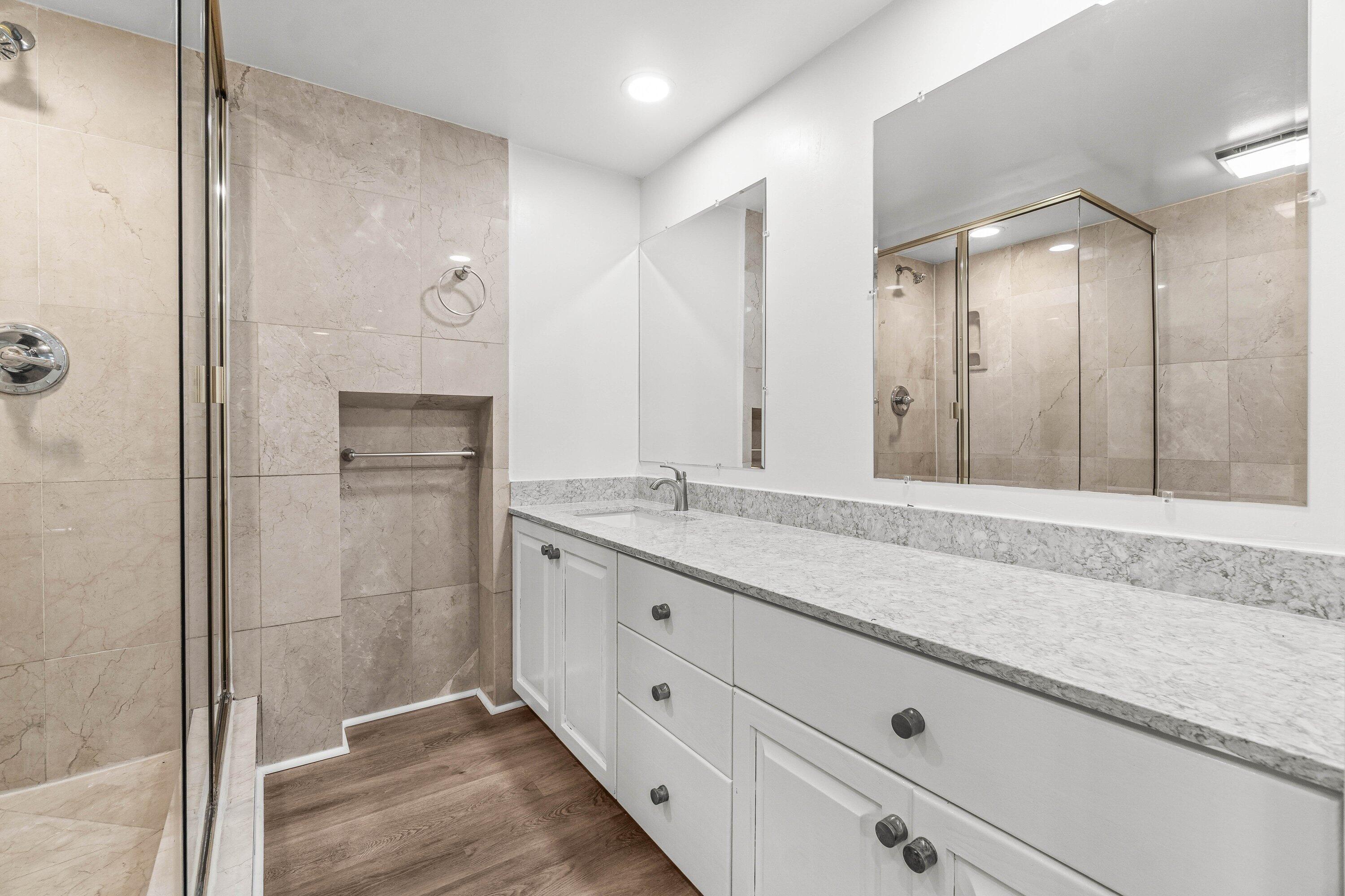 2905 Southwest 22nd Circle, Unit 40A Delray Beach, FL 33445 - Photo 16 of 38 a bathroom with a granite countertop sink mirror and shower