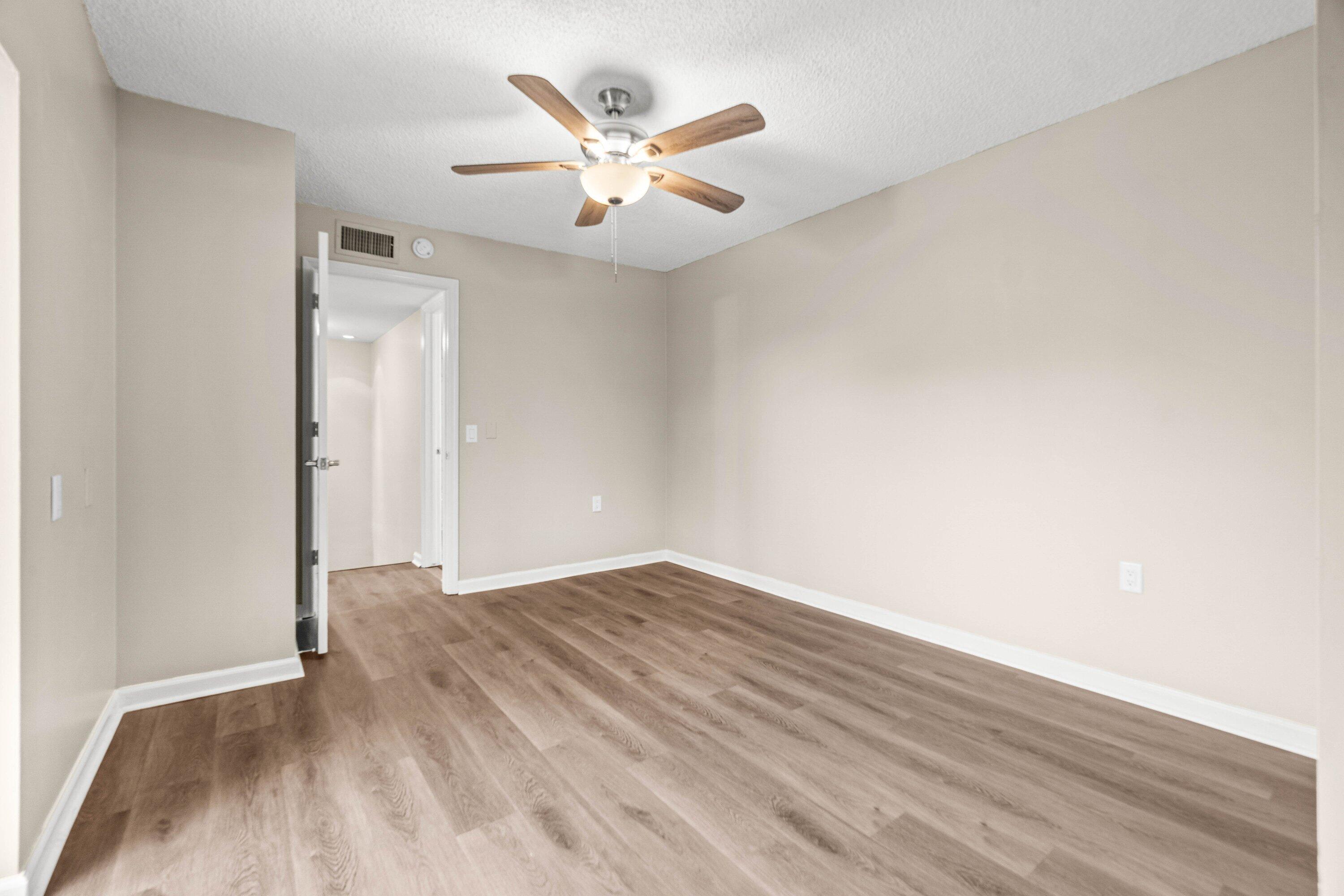 2905 Southwest 22nd Circle, Unit 40A Delray Beach, FL 33445 - Photo 19 of 38 an empty room with wooden floor and ceiling fan