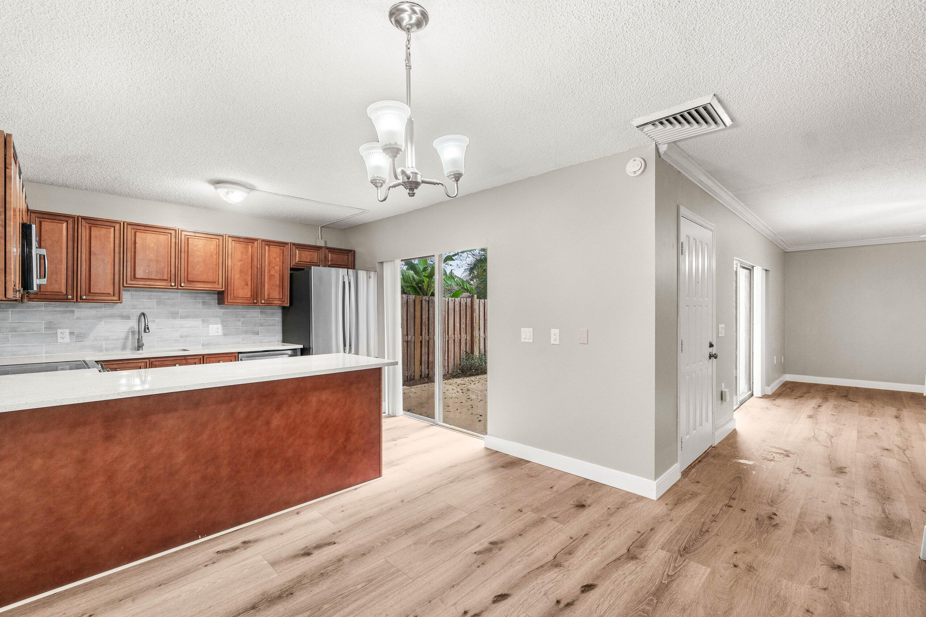 2905 Southwest 22nd Circle, Unit 40A Delray Beach, FL 33445 - Photo 2 of 38 a view of a kitchen with stainless steel appliances granite countertop cabinets and wooden floor