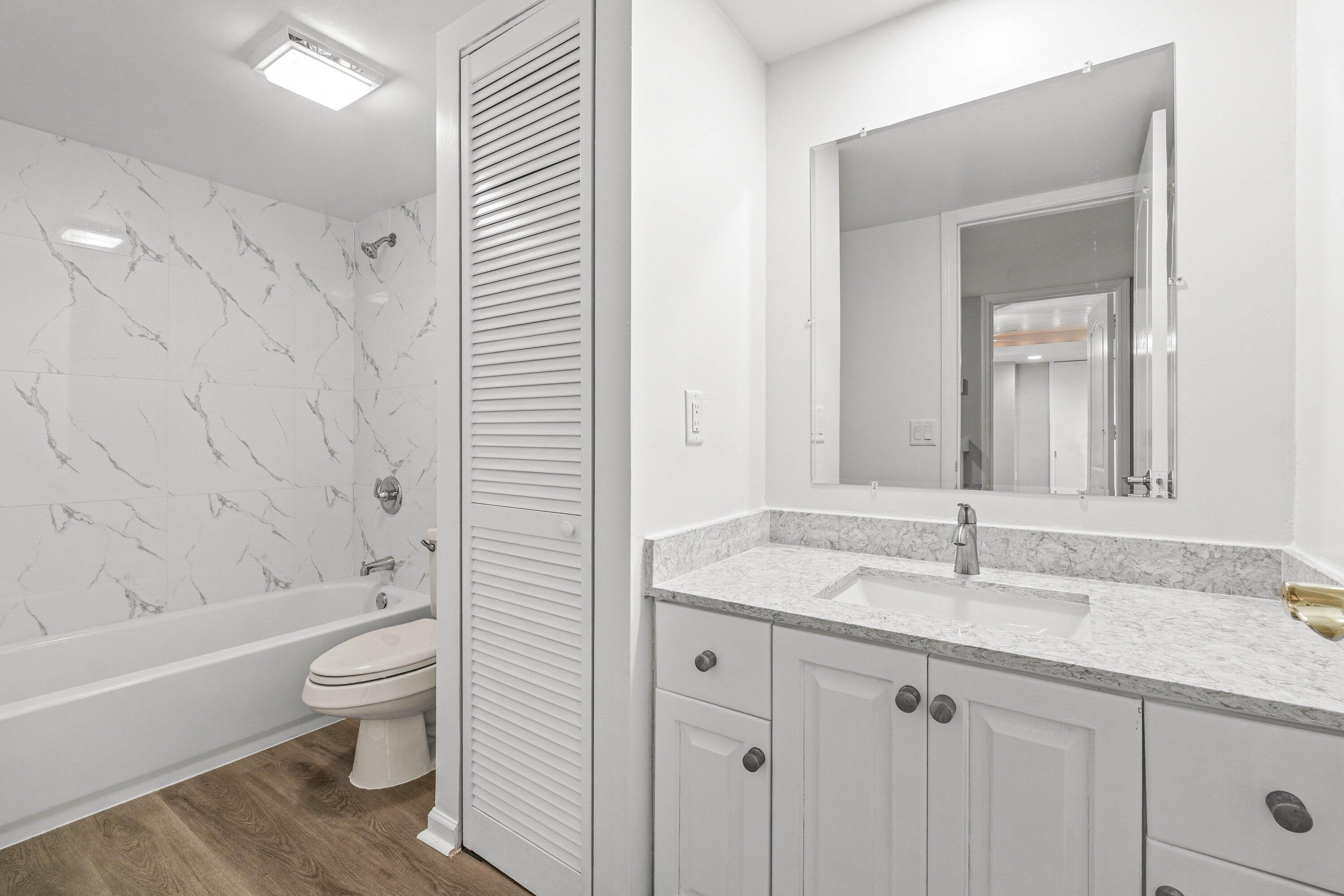 2905 Southwest 22nd Circle, Unit 40A Delray Beach, FL 33445 - Photo 23 of 38 a bathroom with a granite countertop sink toilet and shower