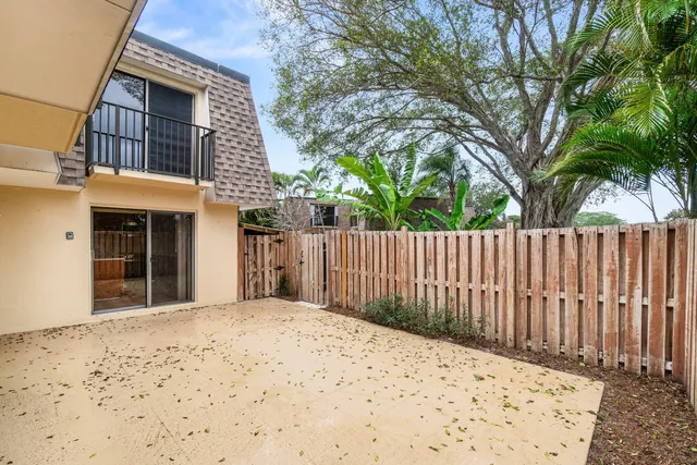 a front view of a house with a large tree