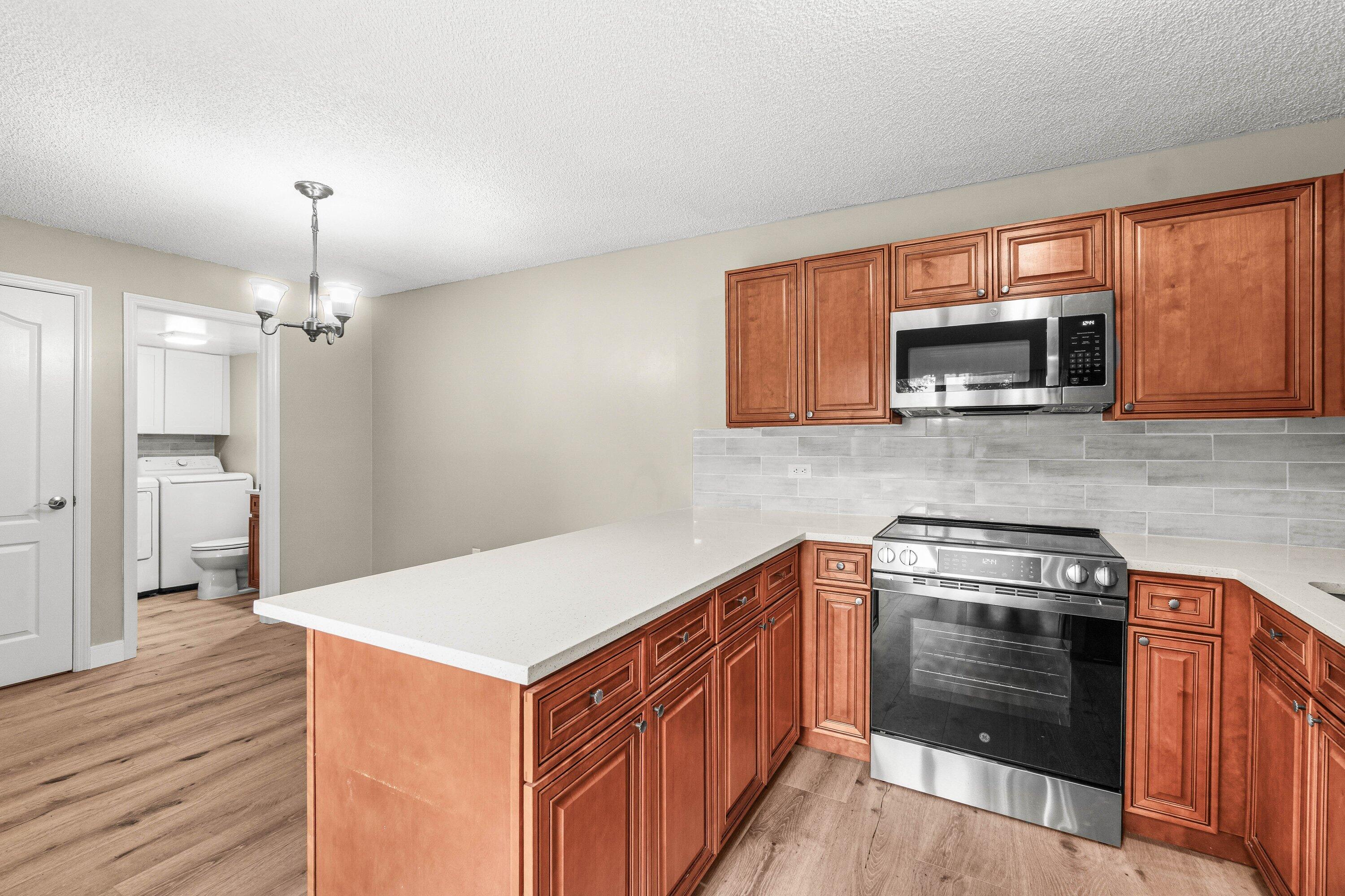 2905 Southwest 22nd Circle, Unit 40A Delray Beach, FL 33445 - Photo 6 of 38 a kitchen with a stove and a microwave