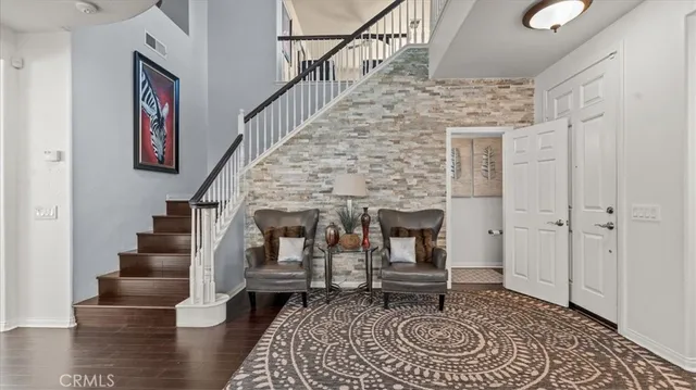 a living room with couches and a fireplace with wooden floor