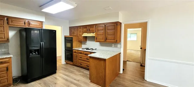 a kitchen with a refrigerator stove and cabinets