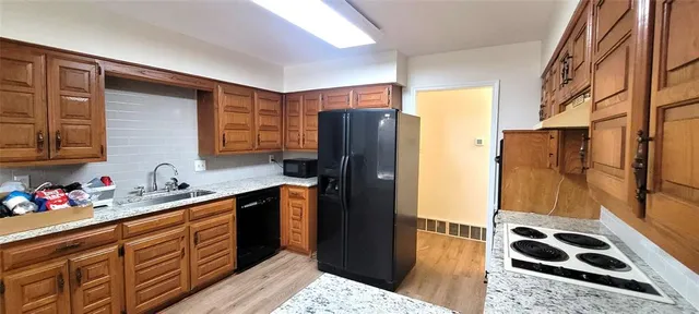 a kitchen with stainless steel appliances granite countertop a refrigerator and a sink